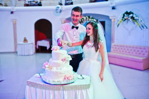 Newlywed  cut wedding cake at restaurant