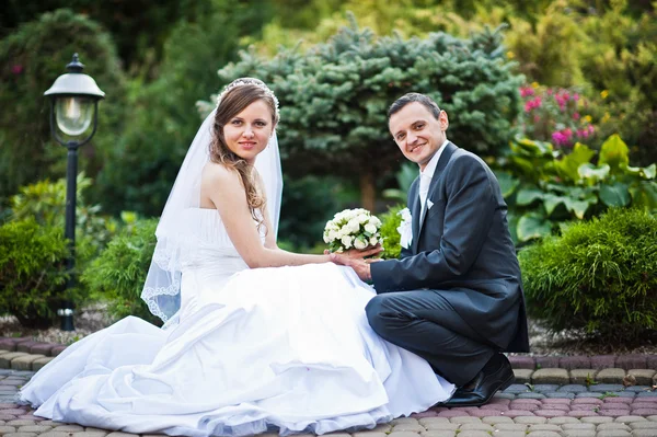 Wedding couple on the yard with ornamental plants and shrubs