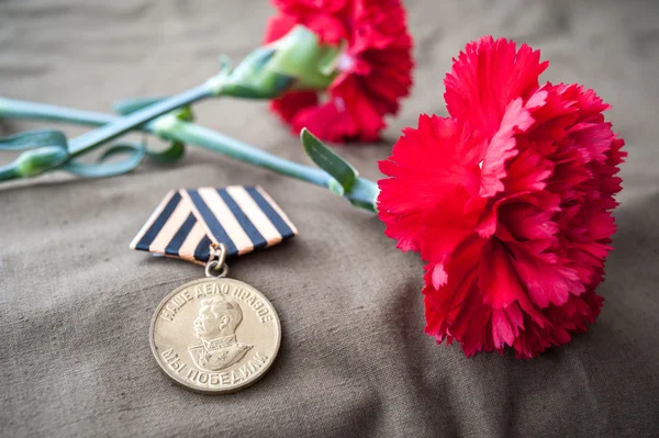 Medal For Victory over Germany in the Great Patriotic War of 1941-1945 and two red carnations