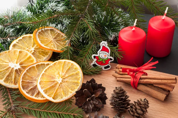 Christmas composition - candle, cones, dried orange, cinnamon, fir tree branch.