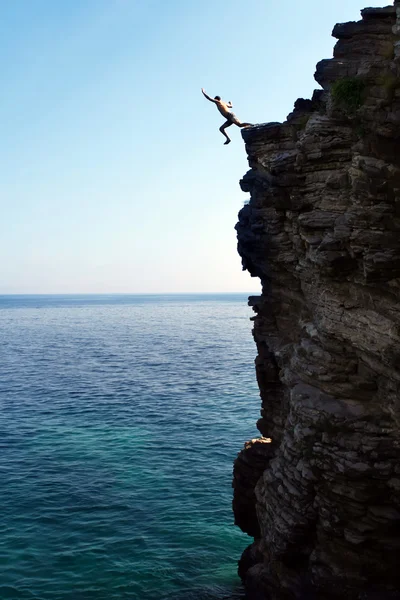Man jumps from a high cliff into the sea