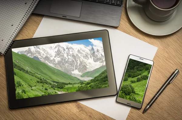 Digital tablet with snow-capped mountains in Georgia on screen
