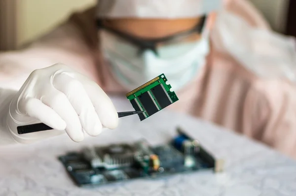 Scientist repairs electronic circuit and holding damaged electri