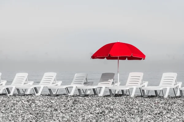 Red sun umbrella and plastic beach beds