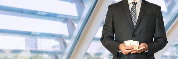 Businessman in black suit counting money