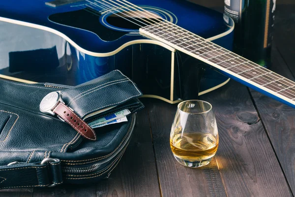 Guitar and whiskey on a wooden table