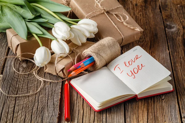 I love you phrase in notebook with flowers on table
