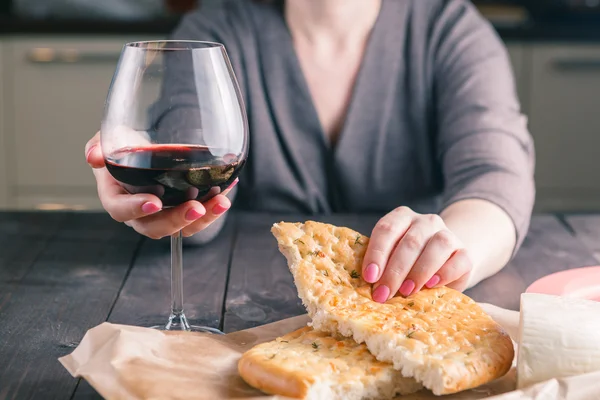 Woman drinking wine and eating bread