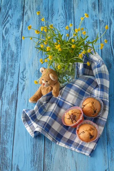 Homemade muffins in blue napkin on blue wood table