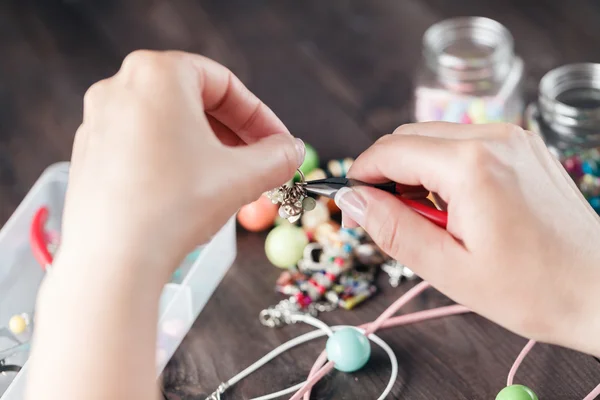 Woman hands making beads, closeup view
