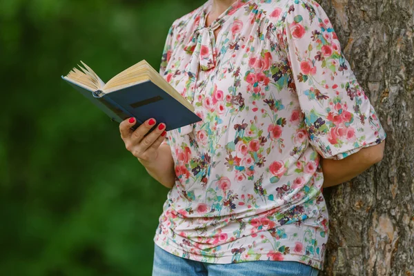 Woman is reading a book in the city park. Education and lifestyl