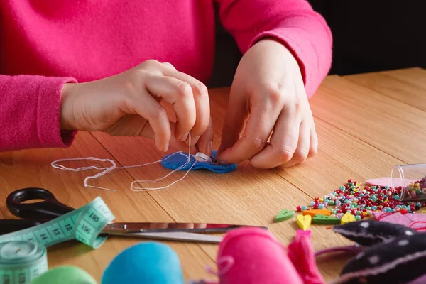 Female hands doing crafts from felt