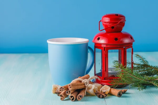 Red lantern and green pine with mug on aquamarine background