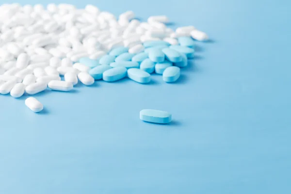 Whiteand blue medical pills on blue background