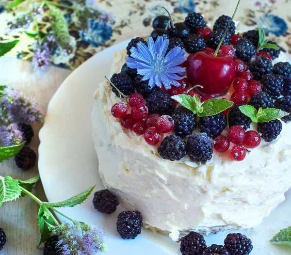 Handmade cake with sweet cream blackberries and red currants