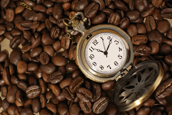 Coffee beans with vintage pocket watch