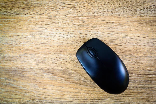 Computer mouse on wooden table background