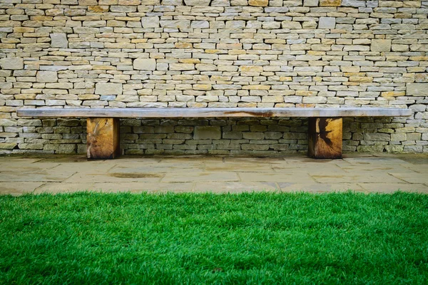 Wooden chair and stone wall background in the garden