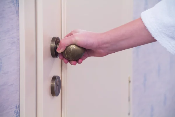 Girl in a white coat opens the door