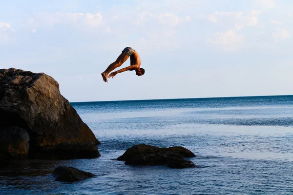 Man jumps from a cliff into the sea