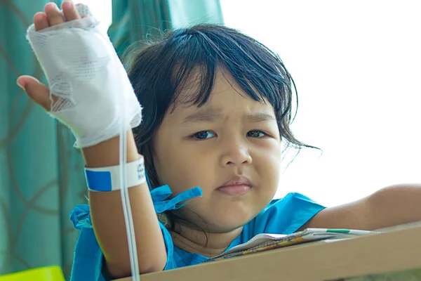 Illness asian kids sit on a chair in hospital, saline intravenou