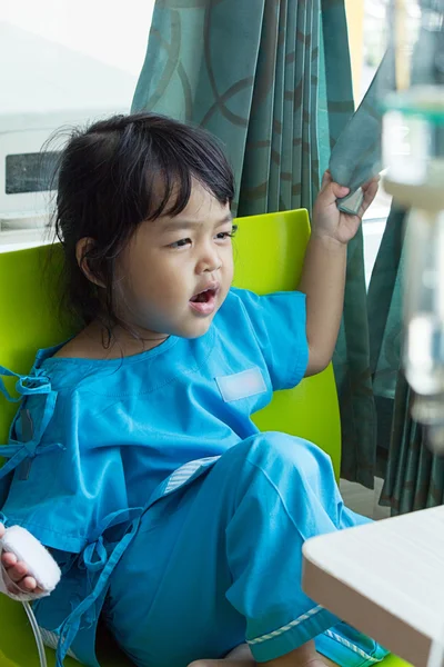 Illness asian kids sit on a chair in hospital, saline intravenou