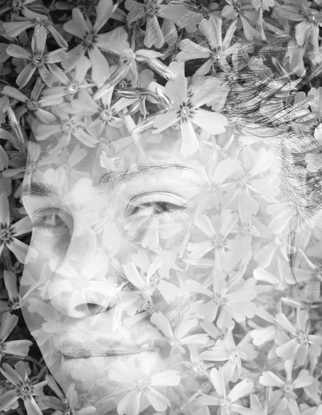 Double exposure: Portrait of young brunette woman and bush of violet flowers black and white