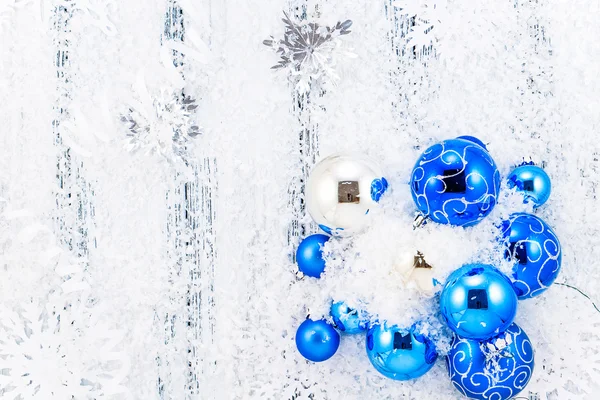 New year theme: blue and silver Christmas tree balls, snow, snowflakes, serpentine on white retro stylized wood background black and white