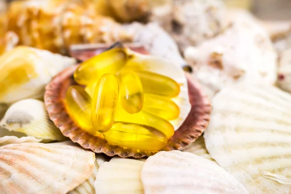 Fatty acid, omega 3 capsules on the beautiful seashells background
