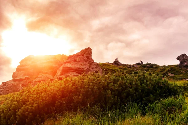 Picturesque scenery of Carpathian mountains, sun over stone, evening time.