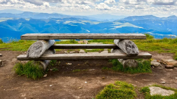 Wooden table and bench for relaxation on the top of Pip Ivan mountain, nature landscape in Carpathians, Ukraine.