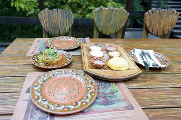 National food in traditional plates with ornaments on a restaurant table