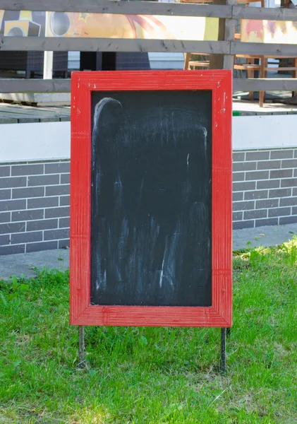 Menu blank board with a street cafe or restaurant in the background