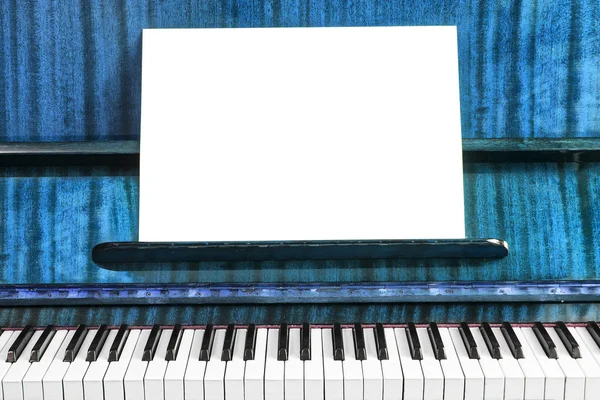 The old piano and sheet of white paper
