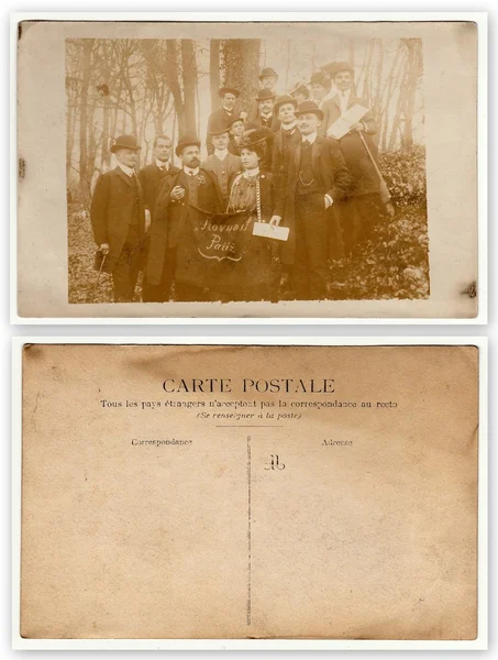 Front and back of vintage photo shows group of people - Czech patriots in France. At the forefront man and woman hold standard with text in Czech: \