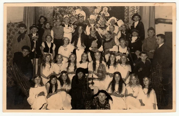 Vintage photo shows pupils to pose after theatre performance. Black & white photo.