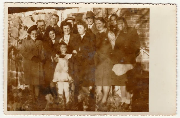 Vintage photo shows a big family poses outdoors. Black & white antique photography.