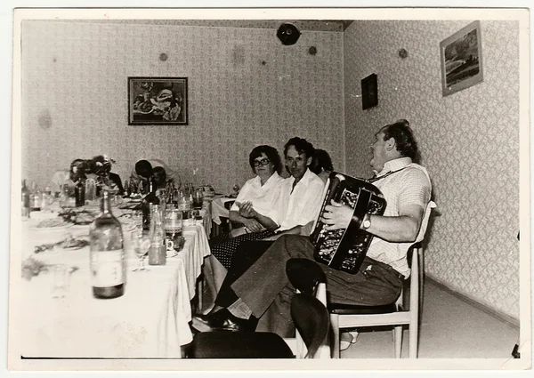 Retro photo shows people at the party. Black & white vintage photography.