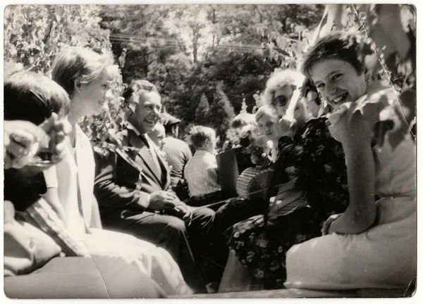 Retro photo shows people ride on rural wedding celebration. Black & white vintage photography.