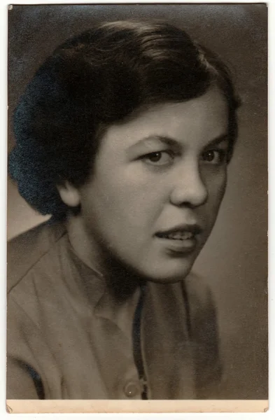 Retro photo shows young woman (studio portrait). Black & white vintage photography.