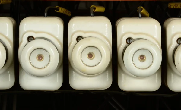White vintage electrical fuses. Old ceramic fuses in switchboard.