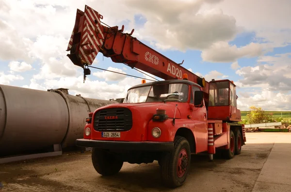 Red mobile crane Tatra AD 20. The truck-mounted crane AD 20 is determined for building and assembly works also in heavy terrain. The truck was made in 1978.