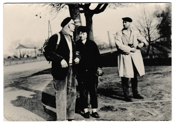 Retro photo shows tourists go for a walk. Black & white vintage photography