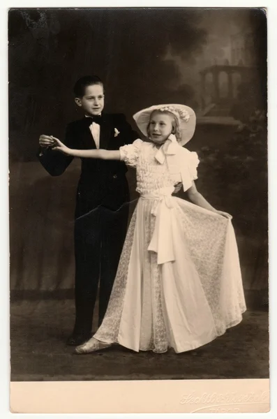 Vintage photo shows a dancing couple (children). A young couple takes dancing lessons. Retro black & white photography.