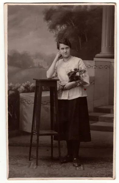 Vintage photo shows woman in a photography studio. Retro black & white studio photography with sepia effect.