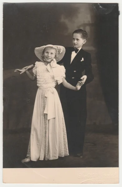 Vintage photo shows a dancing couple (children). A young couple takes dancing lessons. Retro black & white photography.