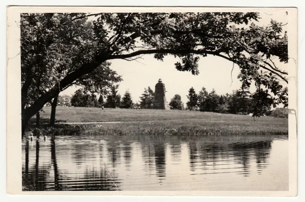 Vintage photo shows the river and a back of the statue on the background. Retro black & white photography.