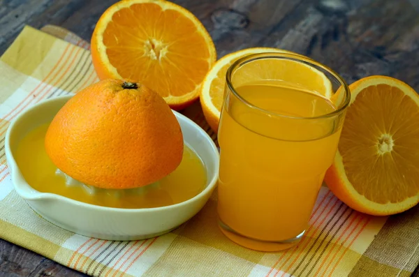 Retreat with orange juice and porcelain juicer on dish towel.