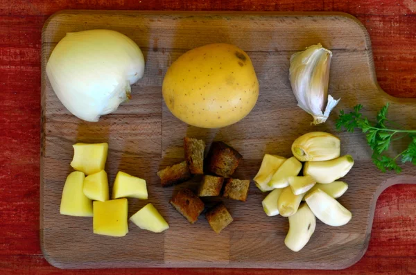 Ingredients for garlic soup on chopping board.