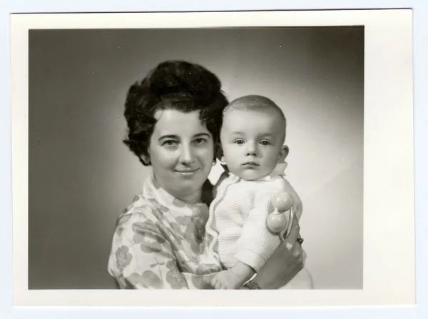 Retro photo shows mother and her son. Portrait photo was taken in photo studio on March, 1972.